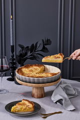 Tarte-Form 28cm Flint mit gebackener Tarte, auf einem Holzständer präsentiert, seitliche Perspektive.