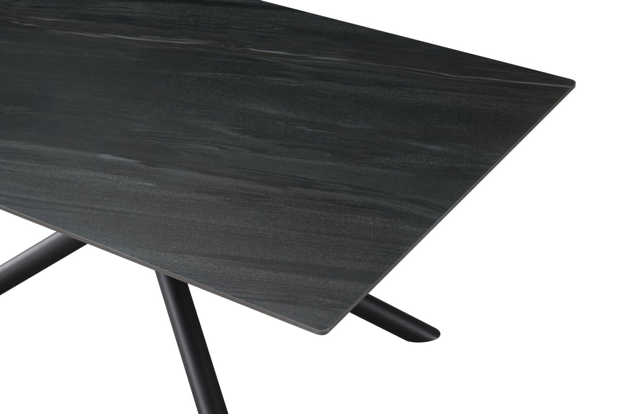 Z2 Esstisch RÜDIGER Nahaufnahme eines modernen Esstisches mit dunkler Tischplatte und schrägen Beinen, Perspektive von oben.