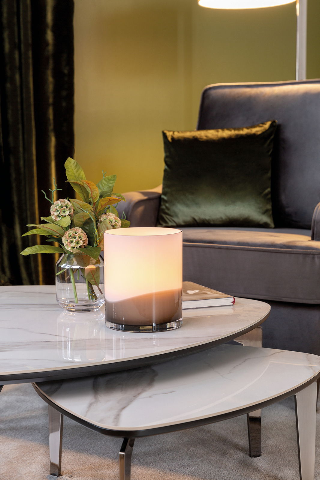 Elegante Vase auf einem Marmortisch, umgeben von einem stilvollen Wohnzimmer mit einem Sessel im Hintergrund, seitliche Perspektive.