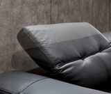 Nahaufnahme eines verstellbaren schwarzen Ledersofas mit Kopfstütze, seitliche Perspektive.