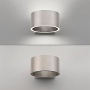 Moderne Wandleuchte PURE Clipse aus gebürstetem Metall, frontal und seitlich beleuchtet.
