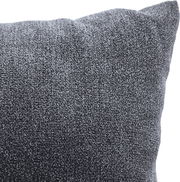 Nahaufnahme eines grauen Kissens mit weicher Textur, perspektivisch von der Seite aufgenommen.