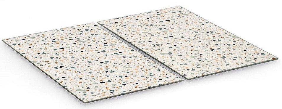 Zwei Herdabdeck- und Schneideplatten mit buntem Terrazzo-Muster, aus schräger Vogelperspektive fotografiert.