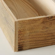 Nahaufnahme eines hölzernen Tabletts mit natürlicher Maserung, aus einer schrägen Perspektive fotografiert.