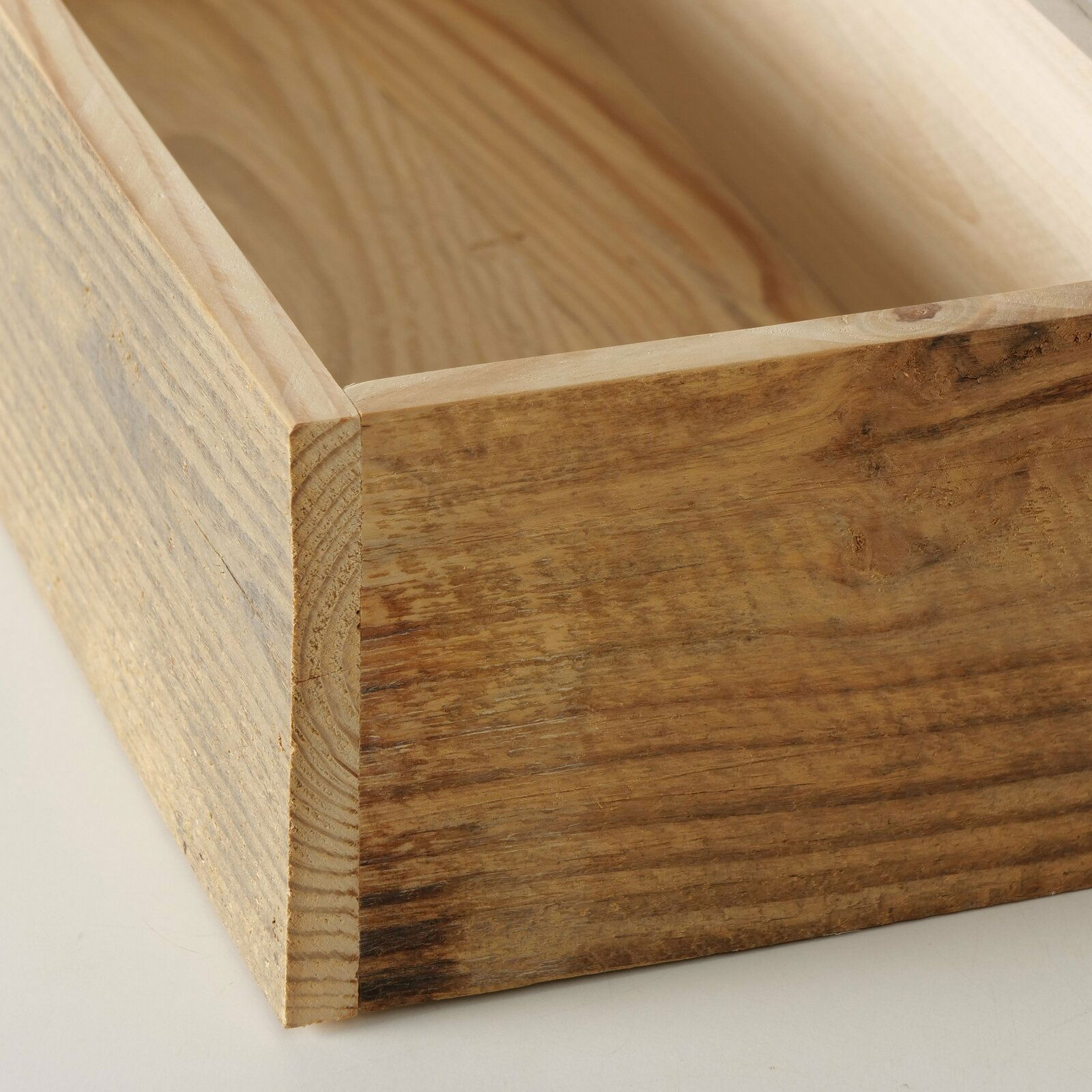 Nahaufnahme eines hölzernen Tabletts mit natürlicher Maserung, aus einer schrägen Perspektive fotografiert.
