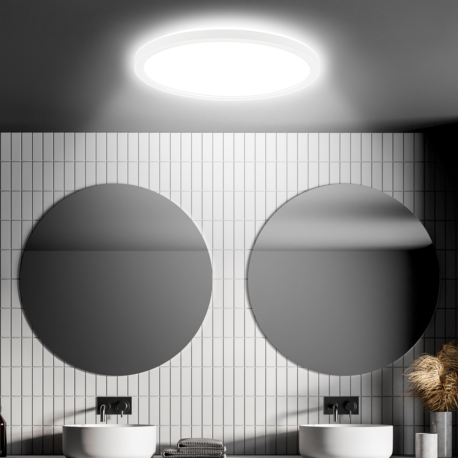 Ronde led-plafondlamp met bewegingssensor, gezien van onderaf, in een moderne badkamer met twee ronde spiegels en witte tegels.