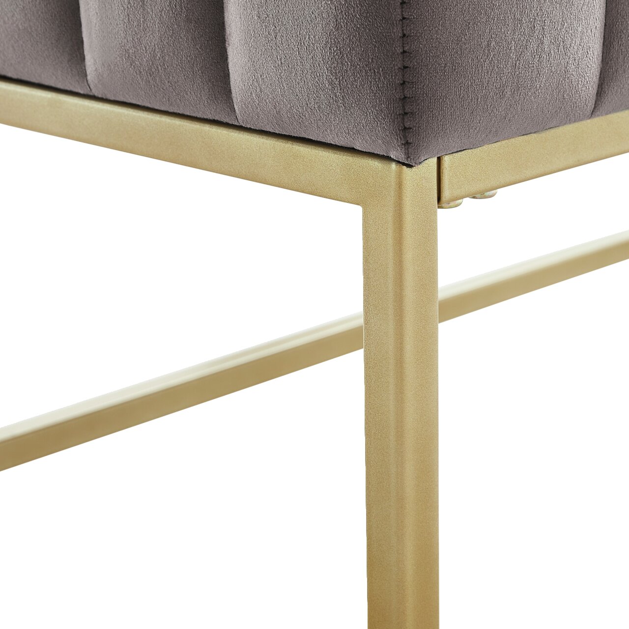 Close-up van een zitbank met grijze bekleding en een goudkleurig metalen frame, gezien vanaf de zijkant