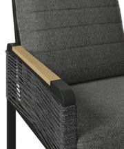 Close-up van een tuinstoel met grijze stoffen bekleding en armleuningen van hout en metaal, gezien vanaf de zijkant.