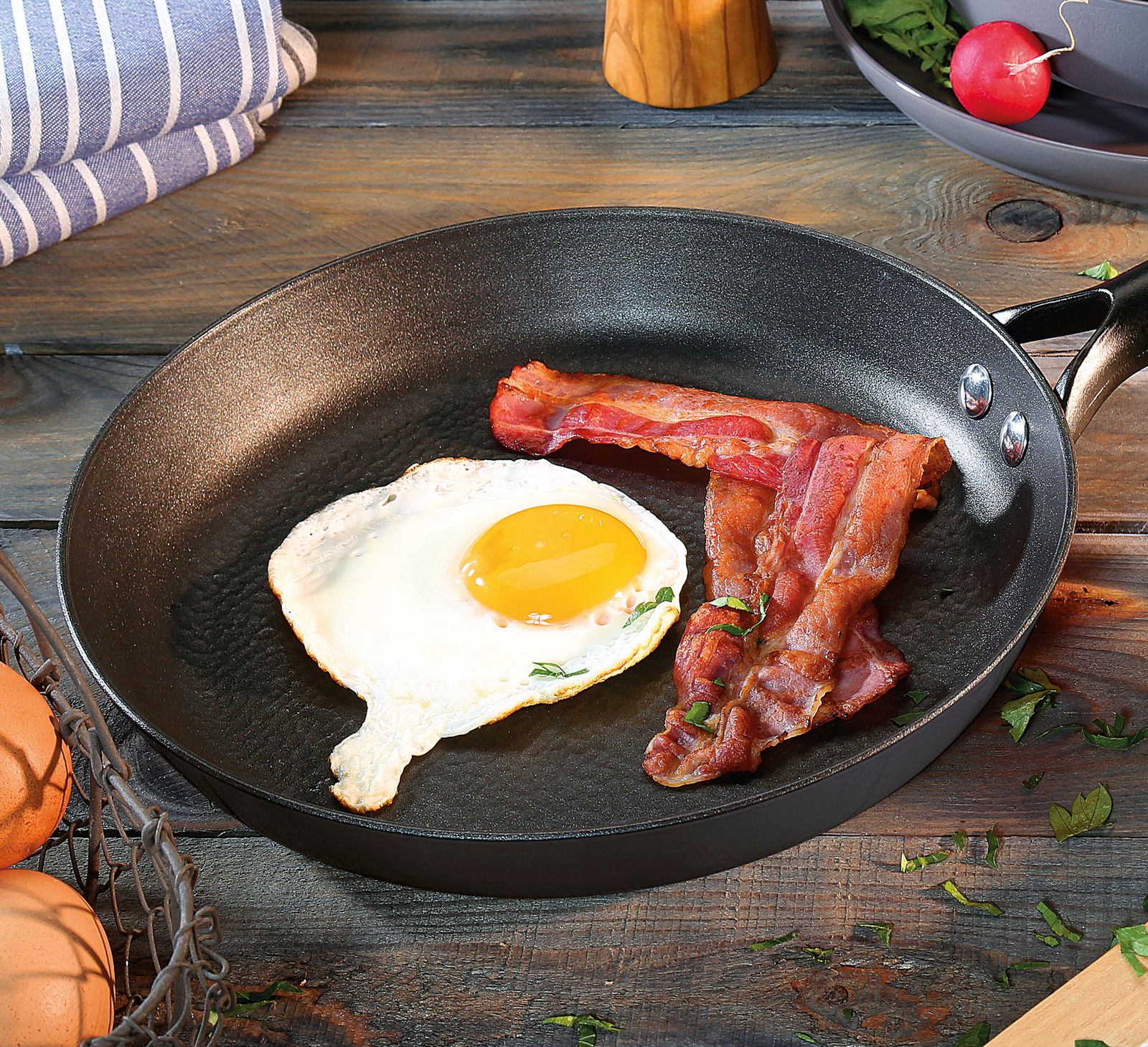 Bratpfanne COUNTRY, 28 cm, mit Spiegelei und Speck, von oben fotografiert auf einem Holztisch.