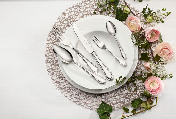 Elegantes Tafelbesteck-Set Mademoisel, 30-teilig, auf einem gedeckten Tisch mit Blumen, Vogelperspektive