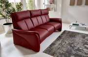 Modernes, weinrotes Trapezsofa mit drei Sitzen in einem hellen Wohnzimmer, seitliche Perspektive.