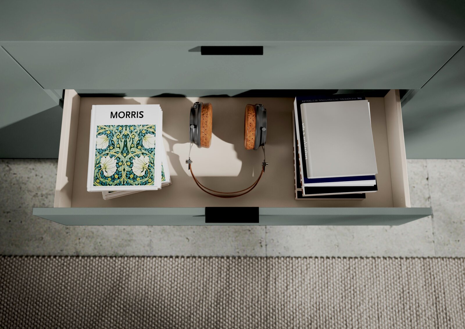 Offene Schublade eines XL-Sideboards mit Büchern, Kopfhörern und Zeitschriften, von oben betrachtet.