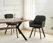 Moderner Essbereich mit zwei dunkelgrauen Polsterstühlen an einem Holztisch mit schwarzen Metallbeinen, seitliche Perspektive im hellen Raum mit Jalousien und Vorhängen