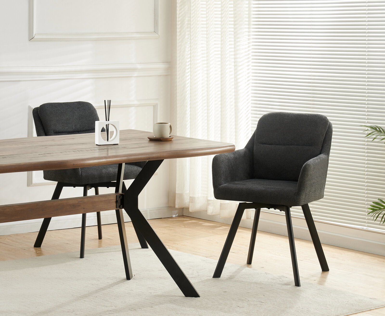 MID.YOU Stuhl 2er-Set SOPHIE Moderner Essbereich mit zwei dunkelgrauen Polsterstühlen an einem Holztisch mit schwarzen Metallbeinen, seitliche Perspektive im hellen Raum mit Jalousien und Vorhängen