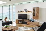 Moderne Wohnwand Voglauer V-ALPIN aus Holz, ohne Beleuchtung, in einem stilvollen Wohnzimmer mit Blick auf die Berge, seitliche Perspektive.
