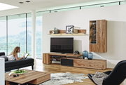 Moderne Wohnwand Voglauer V-ALPIN aus Holz, ohne Beleuchtung, in einem stilvollen Wohnzimmer mit Blick auf die Berge, seitliche Perspektive.