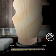 Nahaufnahme einer modernen, wellenförmig geriffelten LED-Tischlampe in warmweißem Licht mit Touch-Schalter am Sockel, frontal aus leichter Untersicht fotografiert; im Hintergrund unscharfer Innenraum und Helligkeitsregler-Overlay