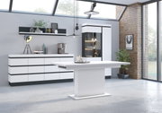 Moderne Wohnzimmereinrichtung mit Sideboard, Vitrine und Esstisch in einem hellen Raum mit großen Fenstern, seitliche Perspektive.