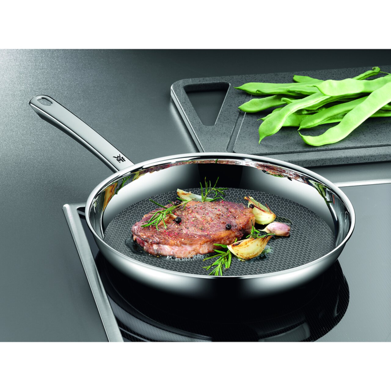 WMF Stielpfanne 28cm PROFI RESIST Stielpfanne Profi Resist 28cm mit gebratenem Steak und Kräutern, seitliche Perspektive