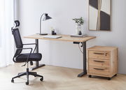 Moderner Arbeitsplatz mit höhenverstellbarer E-Tischplatte aus Holz, schwarzem Bürostuhl und Rollcontainer, seitliche Perspektive.