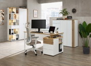 Moderner Büroraum mit Schreibtisch, ergonomischem Stuhl und Büroschränken, seitliche Perspektive.