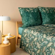 Bettwäsche-Set in Grün mit Paisley-Muster, auf einem Bett mit Holzkopfteil, seitliche Perspektive