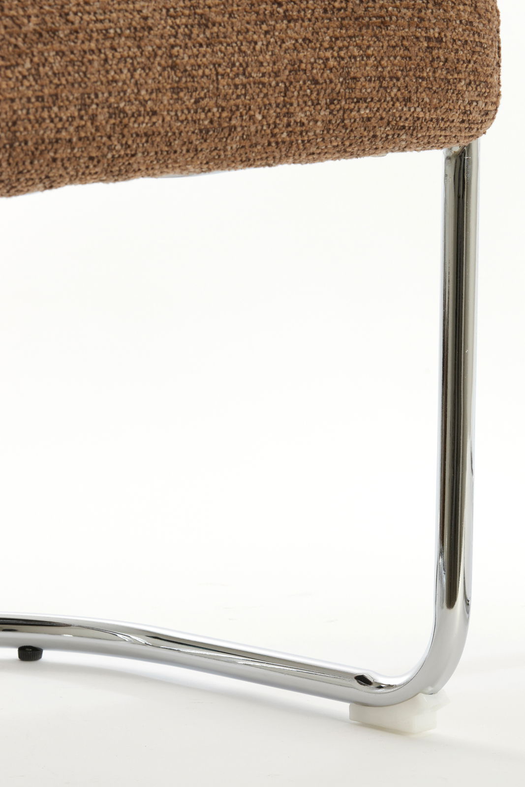 Nahaufnahme eines Armlehnstuhls mit braunem Stoffbezug und verchromtem Metallgestell, seitliche Perspektive.