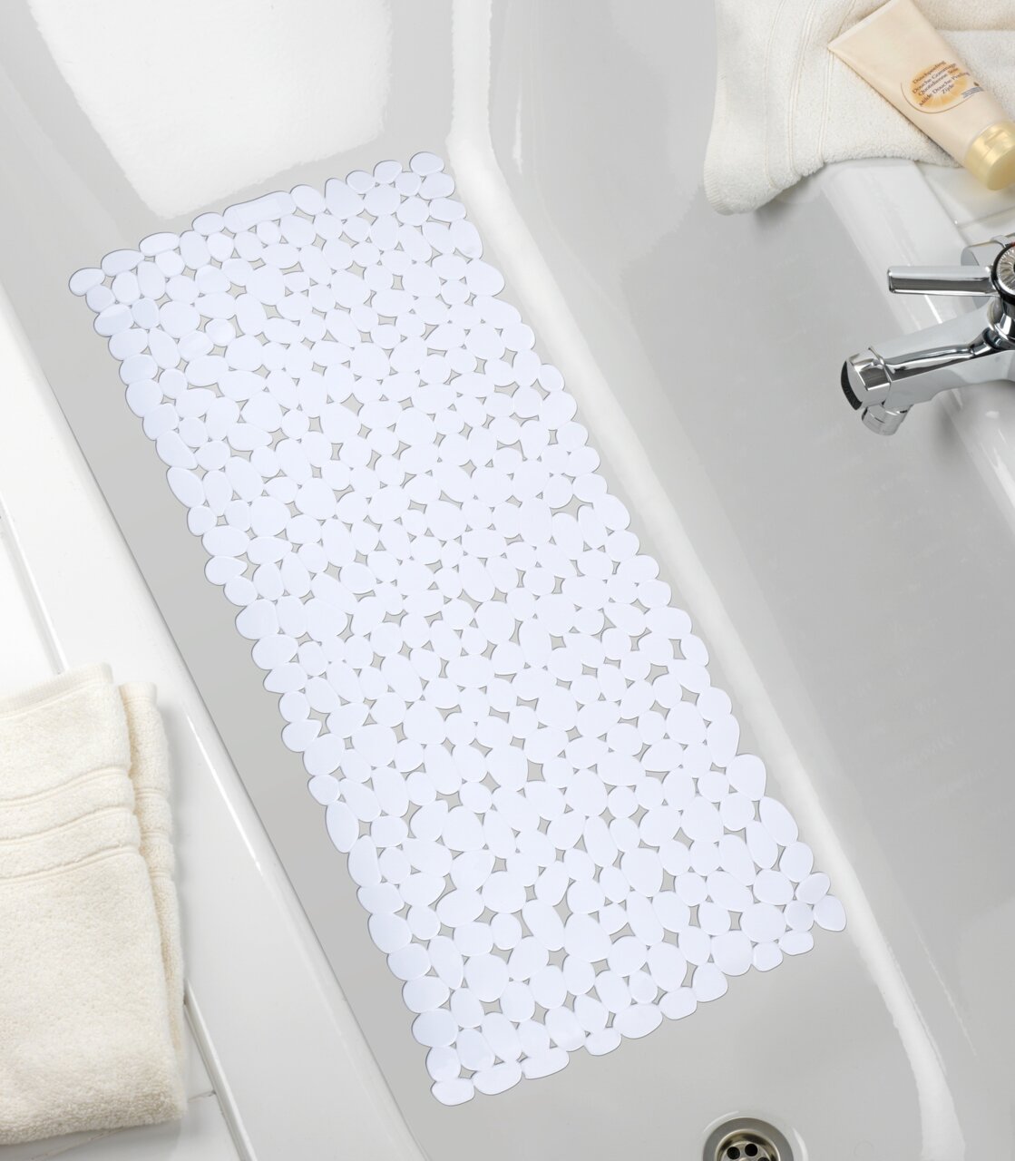 Weiße Wanneneinlage mit Kieselsteinmuster in einer Badewanne, von oben betrachtet.