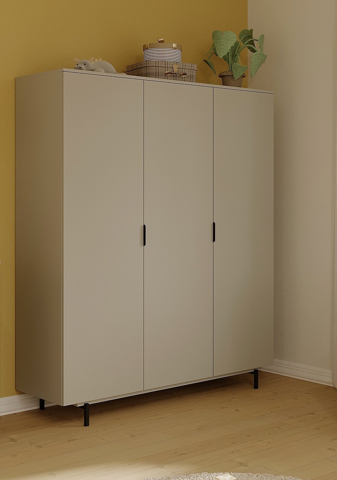 Moderner dreitüriger Kleiderschrank in Beige mit schwarzen Griffen, seitliche Perspektive, dekoriert mit Pflanzen und Boxen auf der Oberseite.