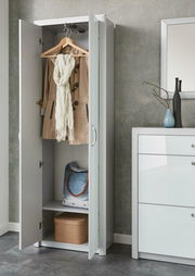 Moderner weißer Garderobenschrank mit geöffneter Tür, zeigt hängenden Mantel und Schal, sowie Ablagefächer mit Tasche und Box, seitliche Perspektive.