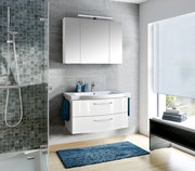Moderne Badezimmeransicht mit weißem Badblock, bestehend aus einem Waschbecken mit zwei Schubladen und einem darüber hängenden Spiegelschrank, seitliche Perspektive.