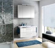 Moderne Badezimmeransicht mit weißem Badblock, bestehend aus einem Waschbecken mit zwei Schubladen und einem darüber hängenden Spiegelschrank, seitliche Perspektive.