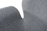 Nahaufnahme eines grauen Sessels mit texturierter Stoffoberfläche, seitliche Perspektive