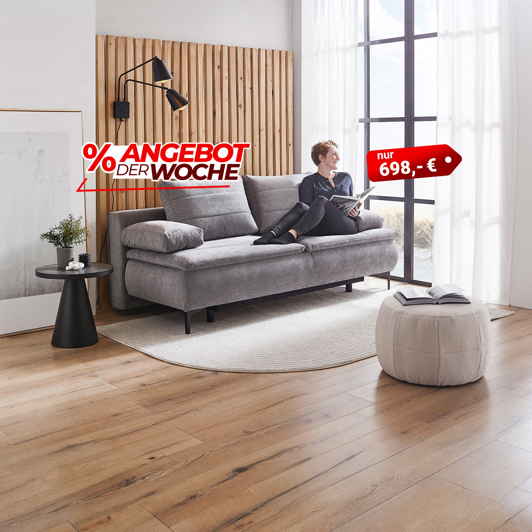 Frau liest auf grauem Sofa im modernen Wohnzimmer, Angebot der Woche Sofa für 698 €