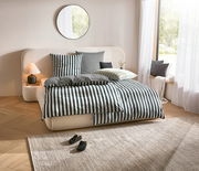 Gemütliches Schlafzimmer mit Marc O'Polo Bettwäsche im klassischen Streifenmuster, frontal aufgenommen. Einladendes Ambiente mit weichen Kissen und natürlichem Licht.