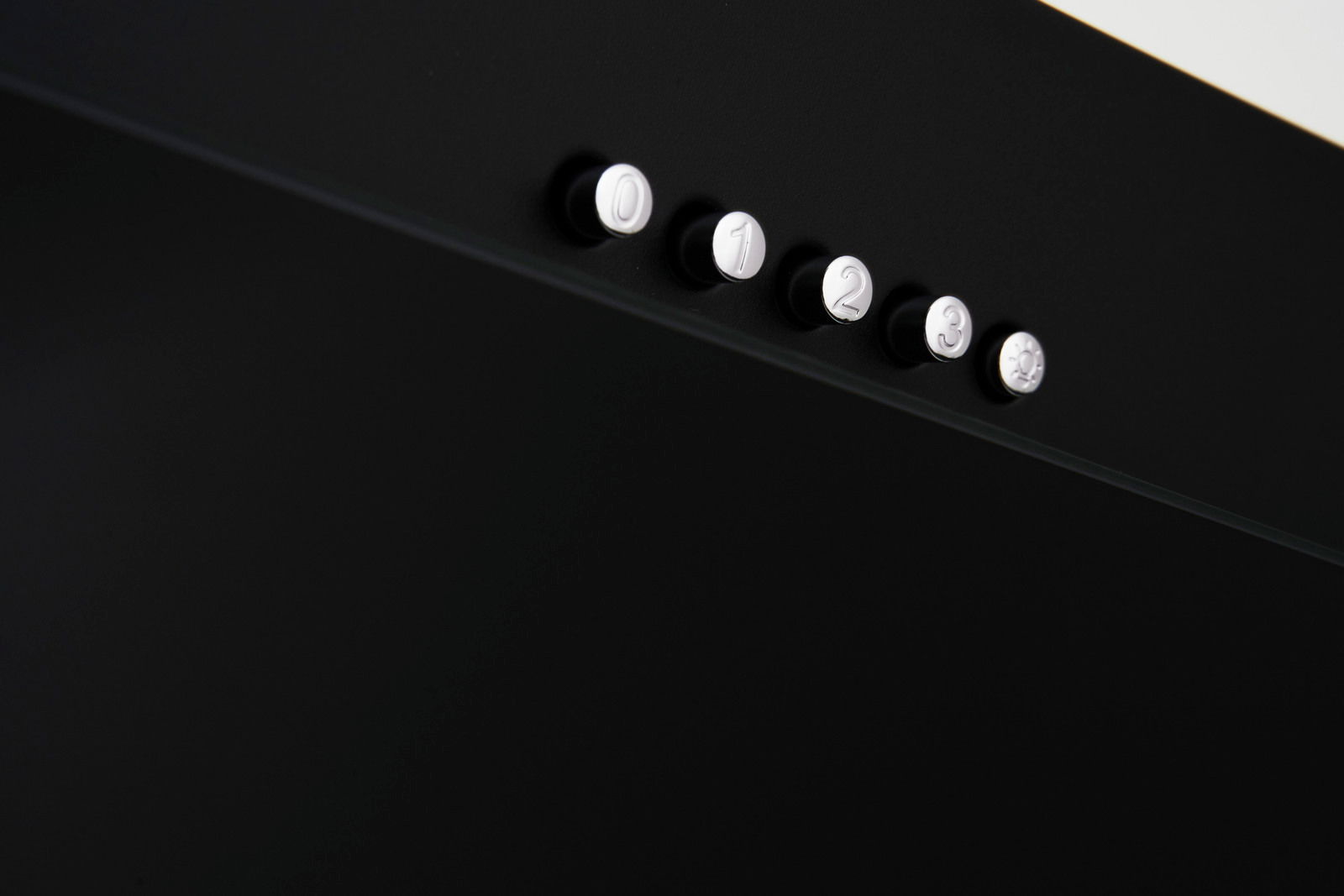 Nahaufnahme von schwarzen Bedienknöpfen mit den Zahlen 0 bis 3 und einem Lichtsymbol auf einer schwarzen Oberfläche, seitliche Perspektive.