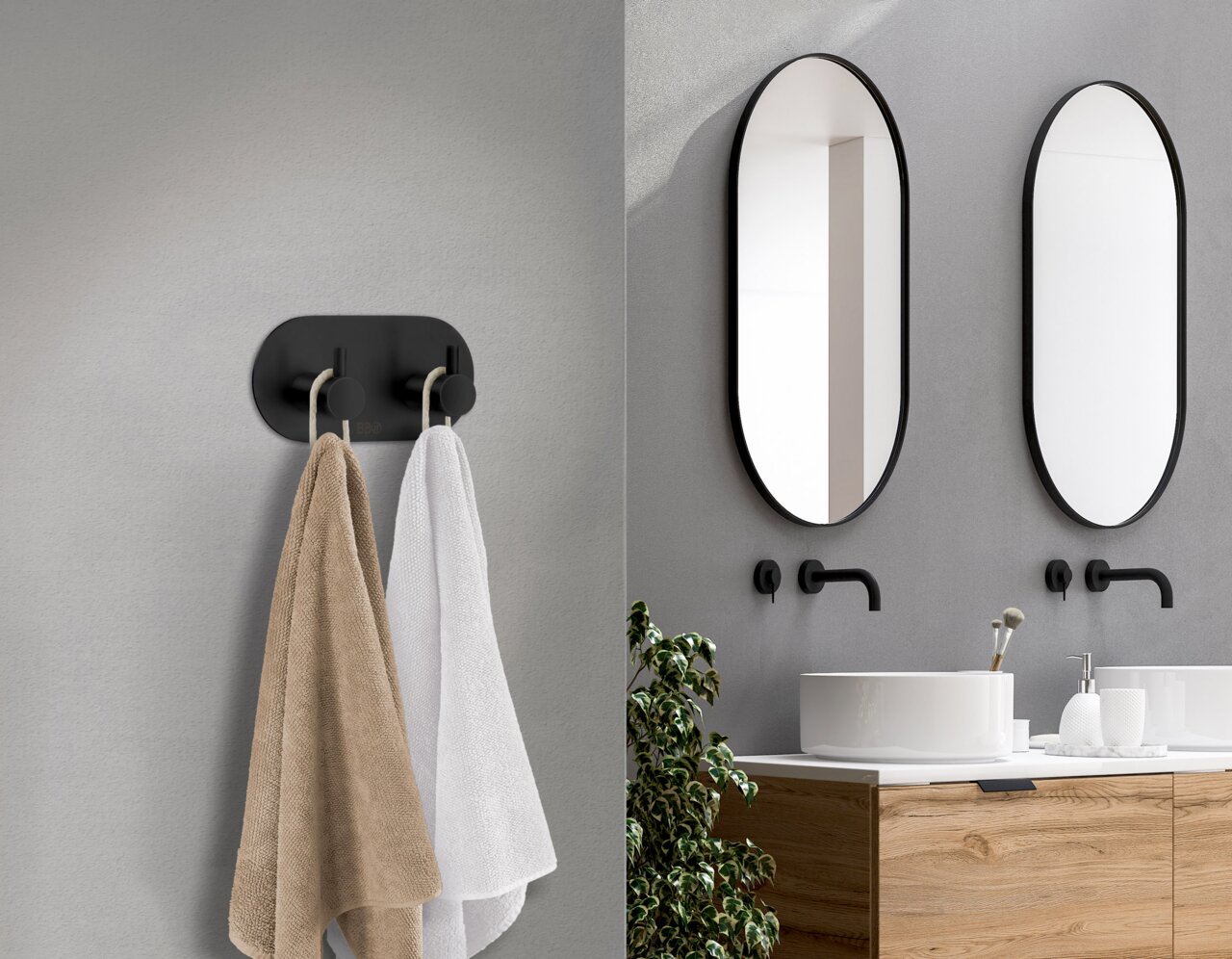 Schwarzer Edelstahl-Doppelhaken an der Wand, frontal betrachtet, mit zwei aufgehängten Handtüchern in einem modernen Badezimmer.