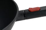 Nahaufnahme eines Guss-Woks mit abnehmbarem Griff und rotem Knopf, seitliche Perspektive