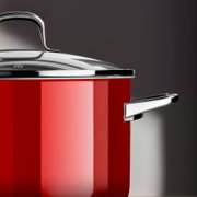 Rode kookpot met glanzend deksel en handvatten, zijaanzicht