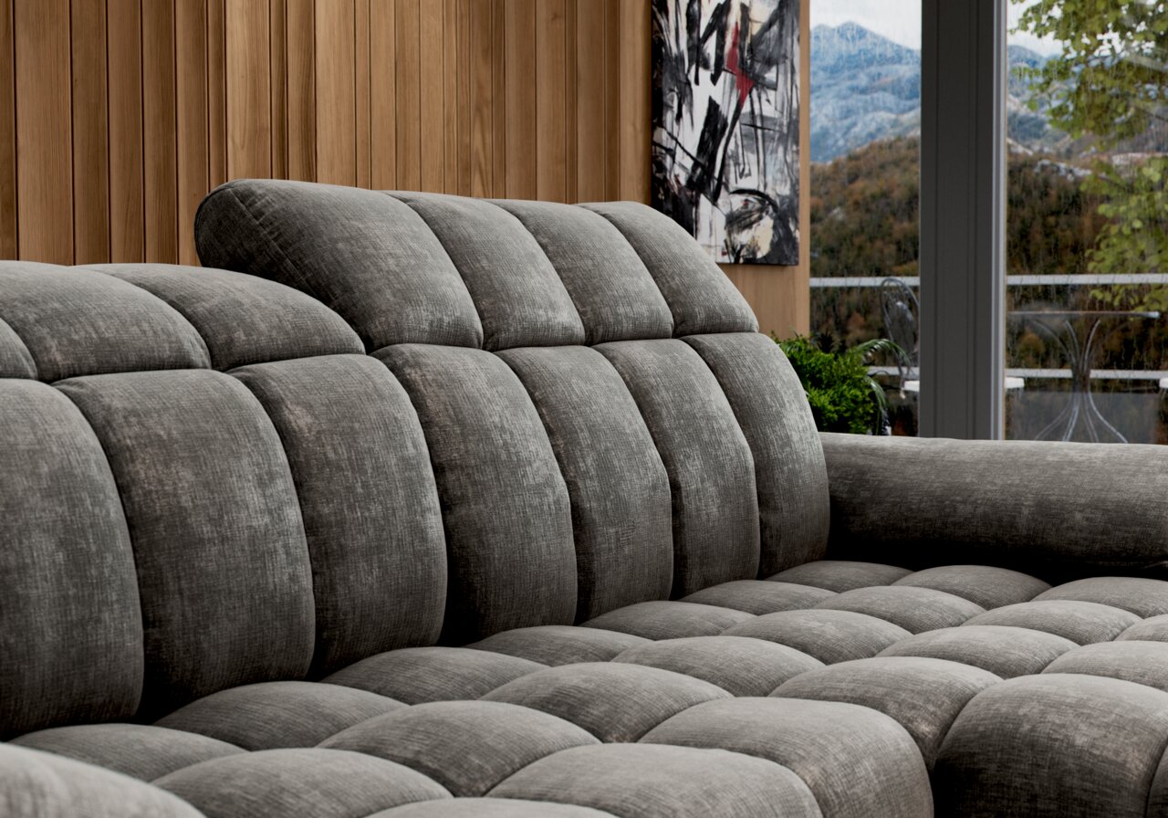 Graues, gepolstertes Longchair-Sofa in einer modernen Wohnumgebung, seitliche Perspektive.