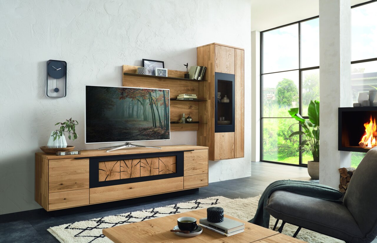 Wöstmann Markenmöbel Wandcombinatie WM 1910 Moderne houten wandopstelling met tv-kast, planken en vitrinekast in een stijlvolle woonkamer, gezien vanaf de zijkant.