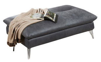 Grauer rechteckiger Hocker mit silbernen Beinen, darauf liegt eine Decke und ein aufgeschlagenes Buch, seitliche Perspektive