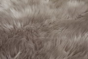 Nahaufnahme eines weichen, grauen Schaffells mit flauschiger Textur.