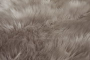 Close-up van een zachte, grijze schapenvacht met een donzige textuur.