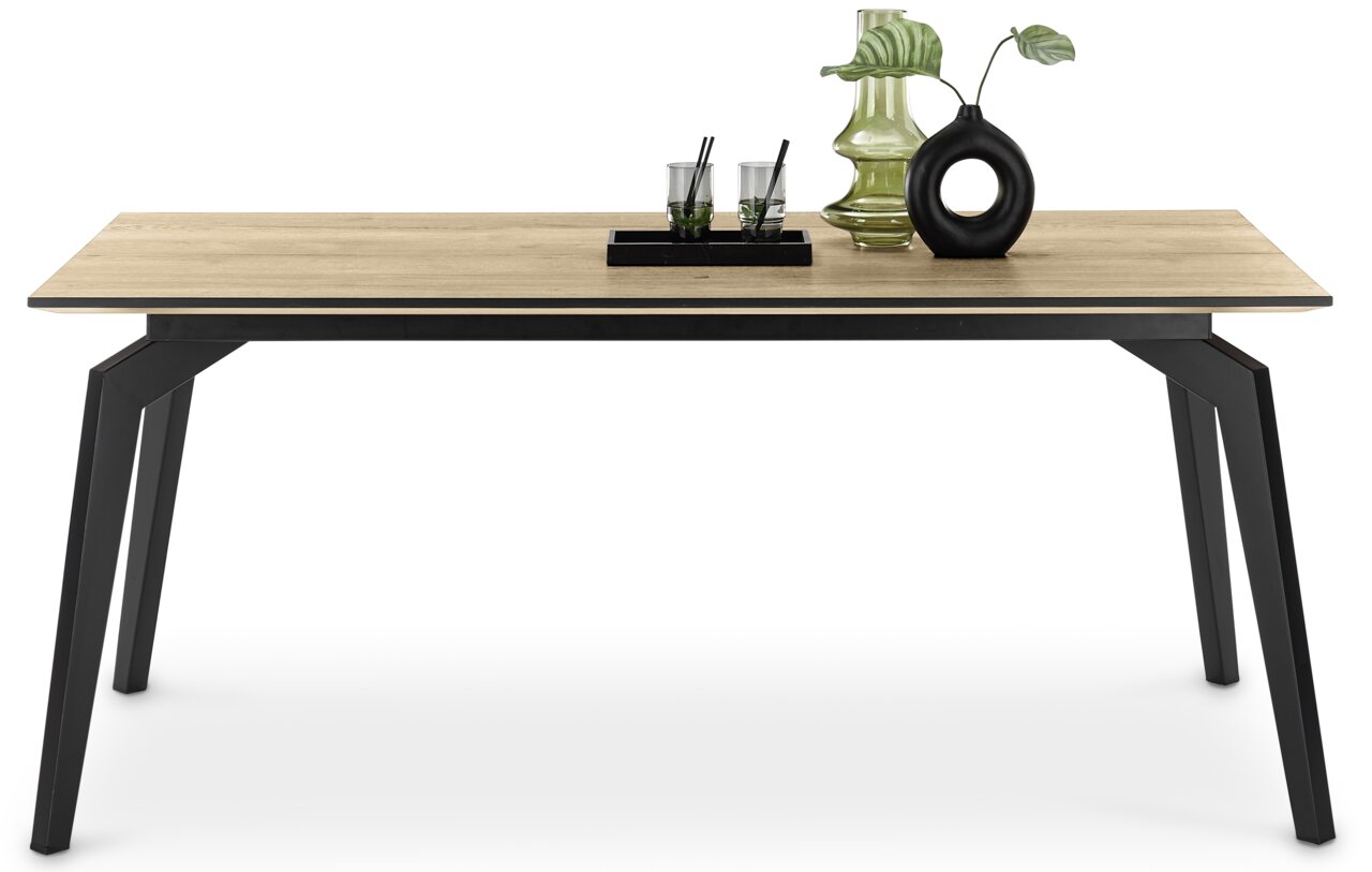 Moderner Esstisch mit Holzplatte und schwarzen Metallbeinen, dekoriert mit Vasen und Gläsern, seitliche Perspektive.