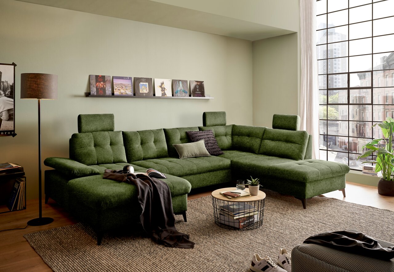 Grünes Ecksofa in modernem Wohnzimmer, Perspektive von vorne links