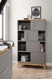 Graues Regal mit Holzakzenten, dekoriert mit Spielzeug und Boxen, aus frontaler Perspektive.