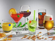 Verschiedene Gläser mit bunten Glasmarkern in Form von Geistern, gefüllt mit verschiedenen Getränken, auf einer weißen Oberfläche. Perspektive: Frontalansicht.