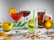 Verschillende glazen met kleurrijke glazen markeringen in de vorm van spoken, gevuld met verschillende dranken, op een wit oppervlak. Perspectief: vooraanzicht.