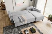 Graues Schlafsofa in L-Form von oben fotografiert, mit einer Decke und einem Kissen dekoriert, in einem modernen Wohnzimmer mit Holzboden und großen Fenstern.